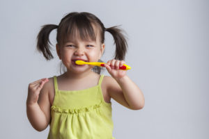 child brushing her teeth