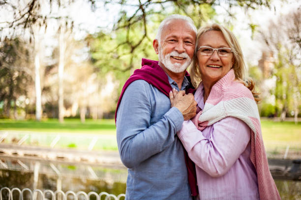 Happy senior couple outside in spring nature, hugging - Shot of a mature older couple hugging